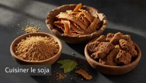 Protéines de soja texturées déshydratées sous forme de granulés, lamelles et morceaux, disposées dans des bols en bois sur un plan de travail en ardoise, éclairées chaleureusement, avec surimpression du texte 'Cuisiner le soja'.