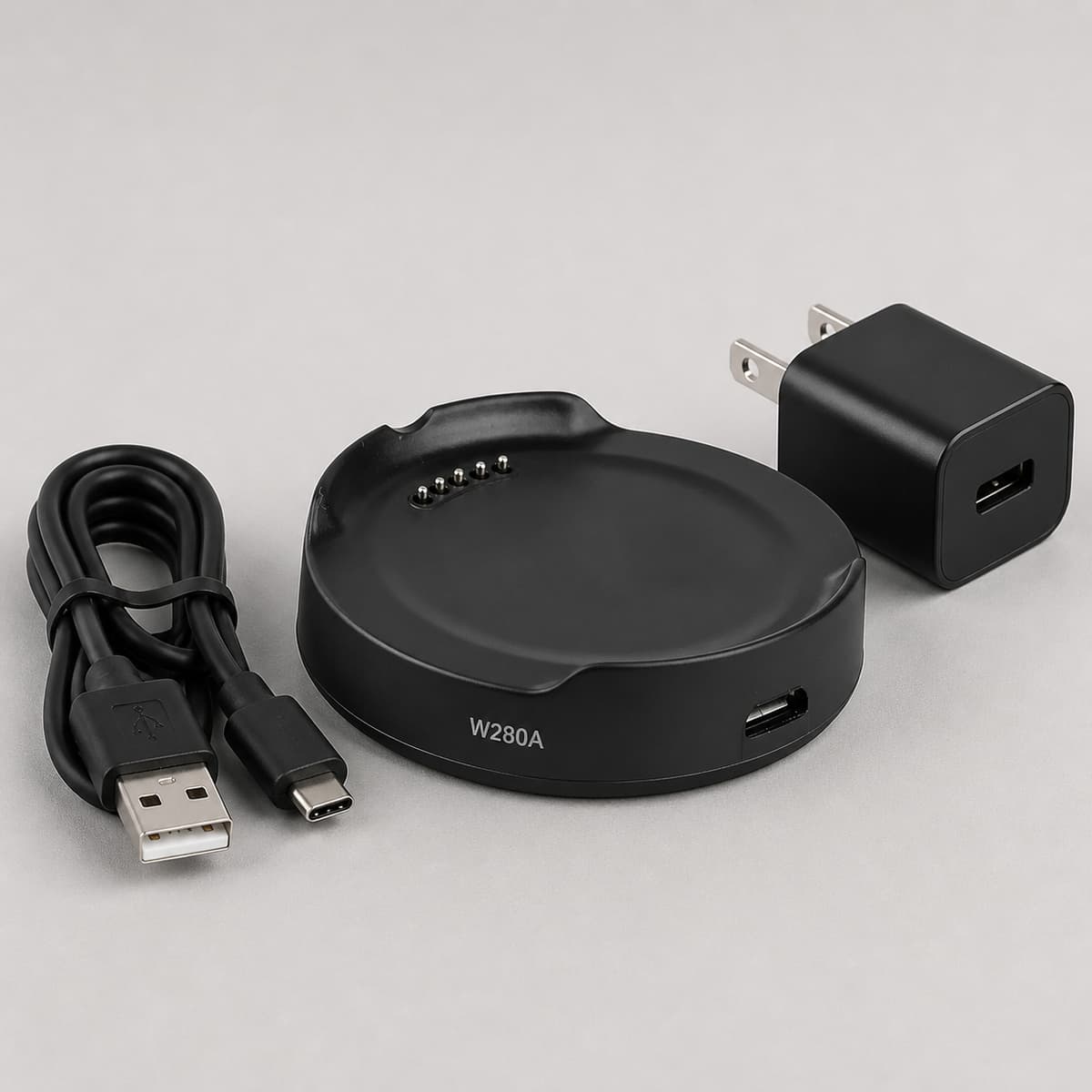 Chargeur de la LG Watch Sport avec sa base de charge, son câble et son adaptateur secteur, référence W280A visible.