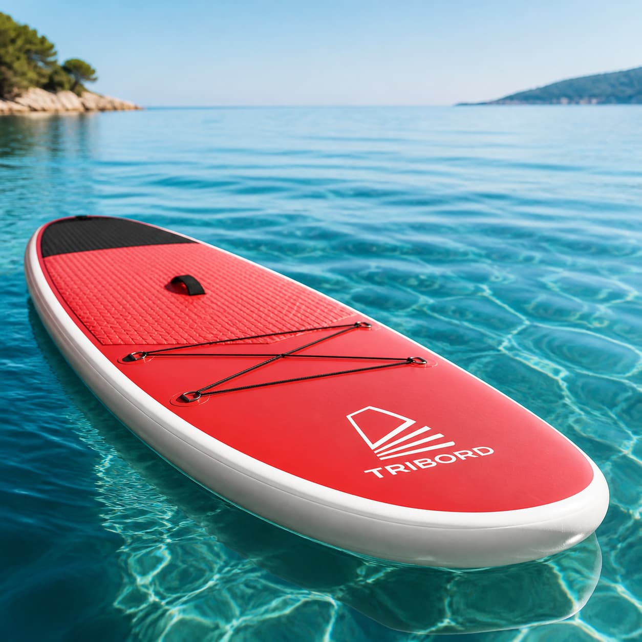 Planche de paddle avec le logo Tribord visible, flottant sur une mer calme.